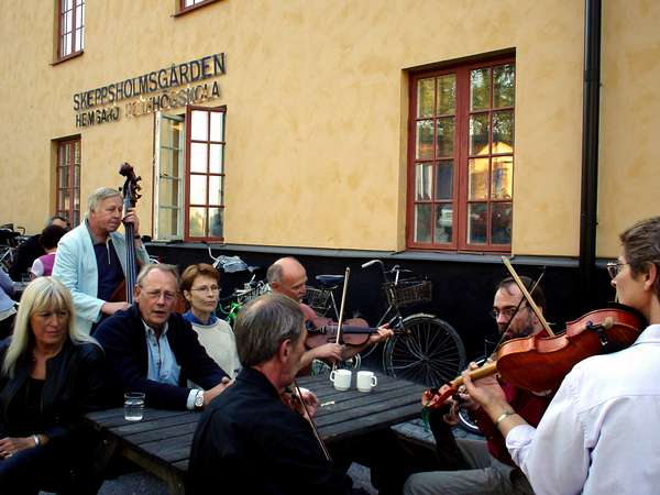 photo of Sweden, central Stockholm, Swedish folk musiscians with violin in front of the Skeppsholmsg&Aring;den Folkhögskola, a cosy centre for Swedish traditional music and culture on the tiny island of Skeppsholmen in central Stockholm