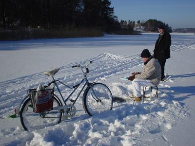 zweden stockholm hagaparken vissen in een gat in het ijs op een bevroren meer met fiets